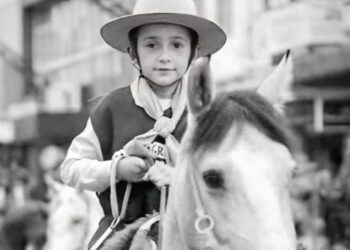 Menino montado em um cavalo.