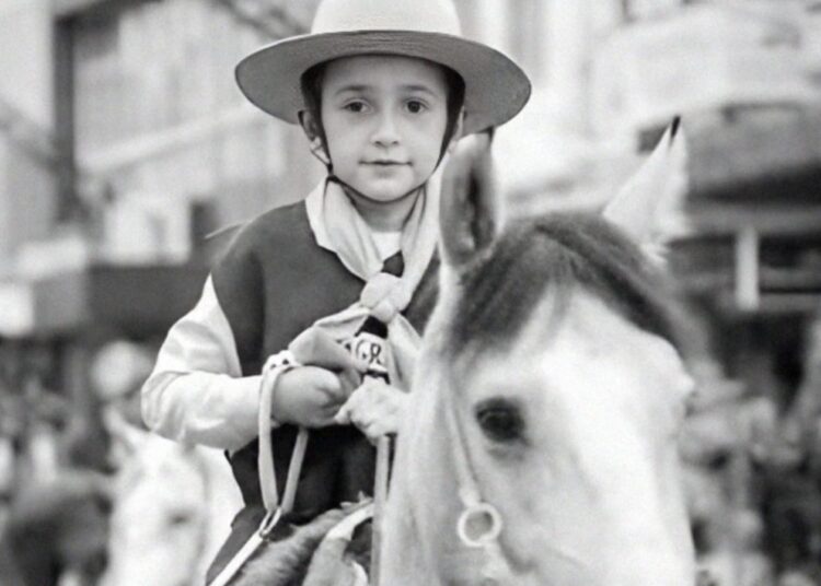 Menino montado em um cavalo.